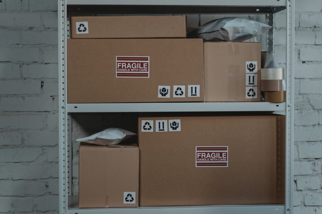 Cardboard boxes labeled 'Fragile' stacked on metal shelving in a storage room.
